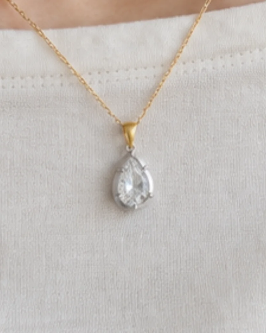 The miniature pear pendant worn on a fine chain with a simple ivory top.